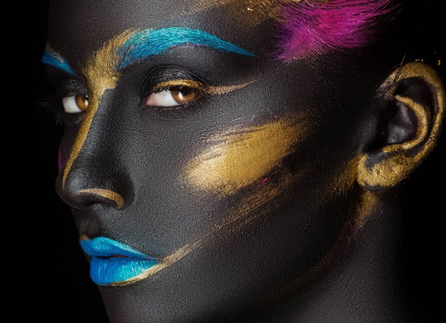 A woman with black and gold makeup on her face.