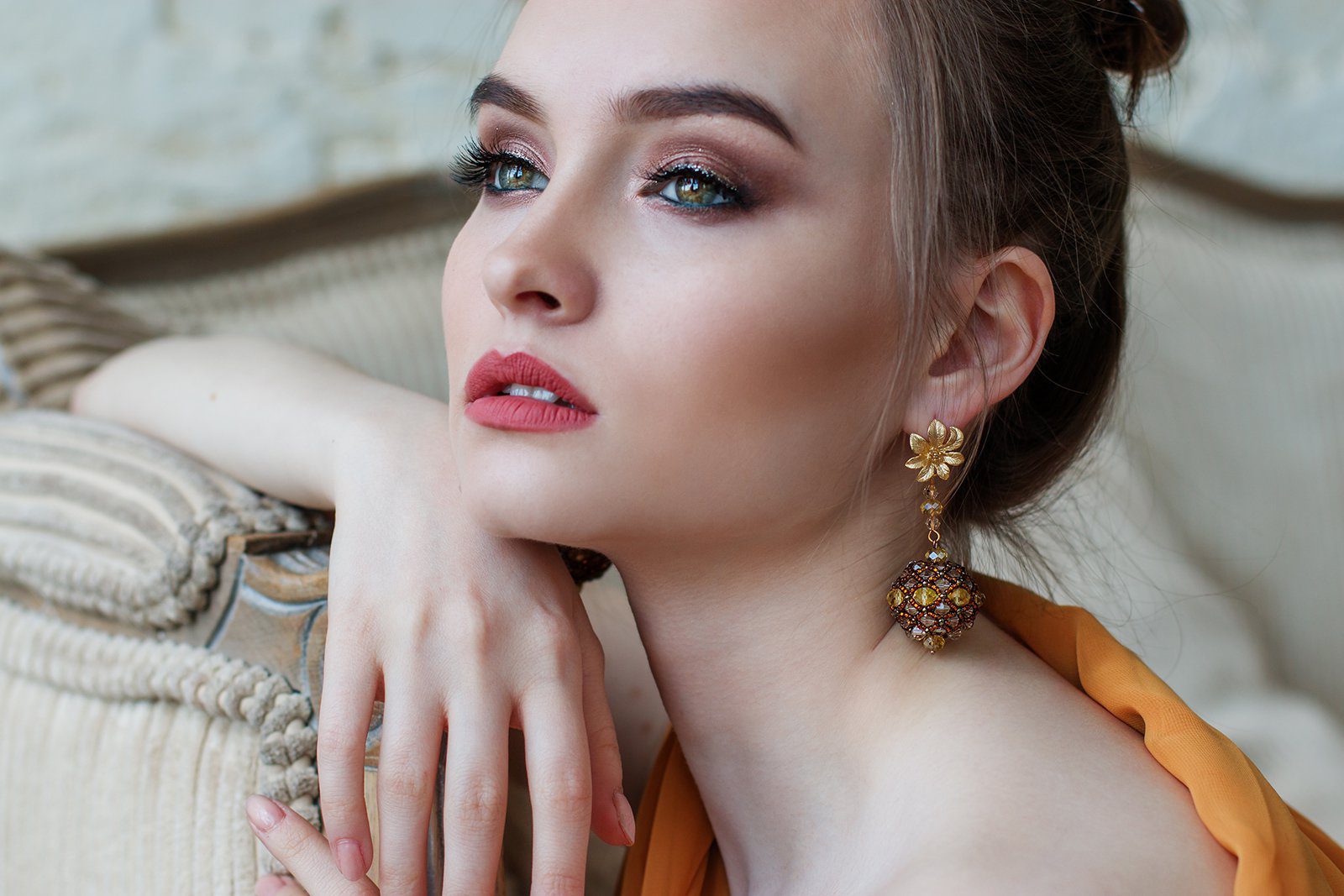 A woman with long hair and wearing earrings.